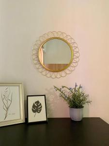 a mirror on a wall above a table with flowers at Rania's House in Methana
