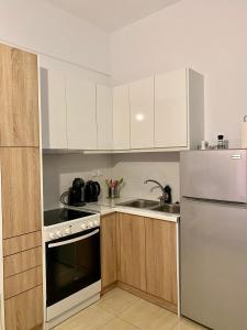 a kitchen with white cabinets and a stainless steel refrigerator at Rania's House in Methana