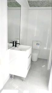 a white bathroom with a sink and a toilet at Stylish Master Suite + Private Bathroom + TV FREE Parking Pet Friendly in Glenfield