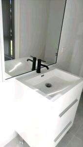 a bathroom with a white sink with a mirror at Stylish Master Suite + Private Bathroom + TV FREE Parking Pet Friendly in Glenfield