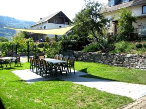 a patio with tables and chairs in a yard at Gästehaus Bollig in Trittenheim