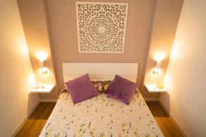 um quarto com uma cama e 2 almofadas roxas em Appartamento Piazza Anco Marzio em Lido di Ostia