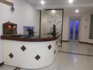 a lobby with a counter in the middle of a room at Hotel Nambi in Madurai