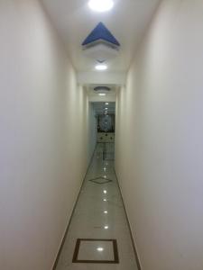 korytarzem w budynku biurowym z niebieskim sufitem w obiekcie Hotel Nambi w mieście Maduraj
