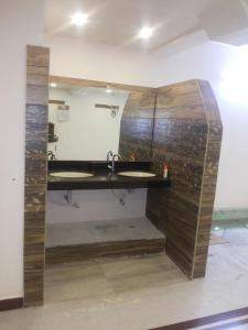 bagno con 2 lavandini e parete in legno di Hotel Nambi a Madurai