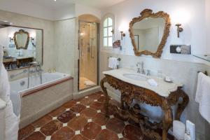 a bathroom with a tub and a sink and a bath tub at Hotel Le Maquis in Porticcio