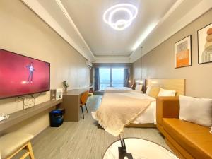 a hotel room with a bed and a flat screen tv at Guangzhou City Inn Hotel Apartment Changgang in Guangzhou +39 photos