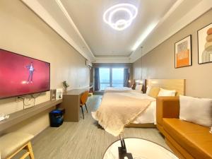 a hotel room with a bed and a flat screen tv at Guangzhou City Inn Hotel Apartment Changgang in Guangzhou