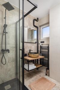 een badkamer met een douche en een houten tafel met een wastafel bij Aenei Delux in Rijeka