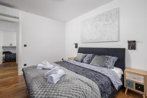 een slaapkamer met een groot bed en handdoeken bij Aenei Delux in Rijeka