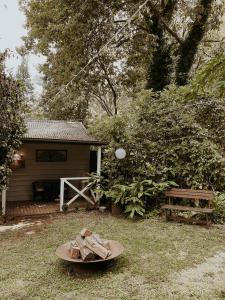 un patio con una casa, una mesa y un banco en Misty Mountain Retreat, en Olinda