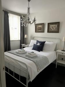 a bedroom with a white bed with two dishes on it at Stylish Boatwright Cottage moments from beach by Whitstable-Holidays in Whitstable