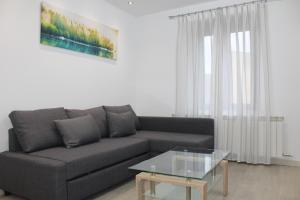 uma sala de estar com um sofá e uma mesa de vidro em Alojamientos Centro Histórico de Ciudad Rodrigo em Ciudad-Rodrigo