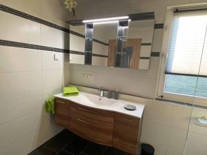 ein Bad mit einem Waschbecken und einem Spiegel in der Unterkunft Ferienhaus Am Alten Kirchsteig in Helmbrechts