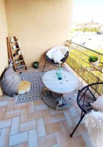patio ze stołem i krzesłami na balkonie w obiekcie Un nid d'amour w mieście Ruoms