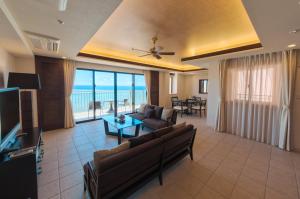 a living room with a couch and a table at Kafuu Resort Fuchaku Condo Hotel in Onna