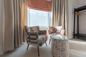 ポーツマスにあるFlorence Suite Boutique Hotel and Restaurantの窓のある客室で、椅子2脚とテーブル1台が備わります。
