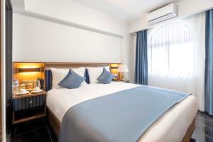 - une chambre avec un grand lit blanc et des oreillers bleus dans l'établissement THE BOSFOR HOTEL, à Istanbul