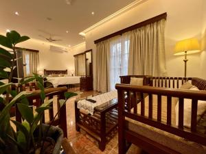 een woonkamer met een bank en een bed bij Rosewood By The Beach Goa in Benaulim