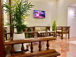 a living room with a bench and a potted plant at Rosewood By The Beach Goa in Benaulim