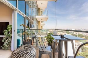 balcón con mesa y sillas y ventana grande en Amani Luxury Apartments Nairobi en Nairobi