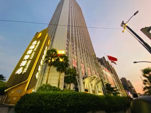 広州市にあるGuangzhou City Inn Hotel Apartment Changgangの木の目の前の高い建物