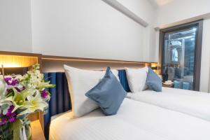 THE BOSFOR HOTEL في إسطنبول: غرفة نوم بسريرين مع وسائد زرقاء وبيضاء