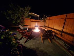 a patio with two chairs and a bench at night at Sunkissed, Est 2015 - 90 Sec Drive to Beach, Firepit, Privacy Fenced Yard, Gardens in Pacific Beach