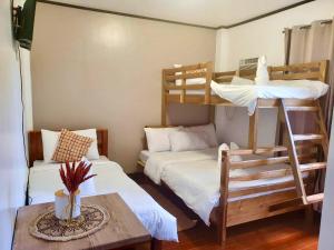 a room with two bunk beds and a table at Jewel Tourist Inn in Coron