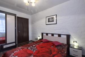 a bedroom with a bed with a red comforter at EvroApartment on Moskovskaya in Saint Petersburg