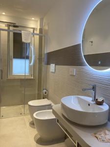 a bathroom with a sink and a toilet and a mirror at Divina Holiday - Rooms in Maiori