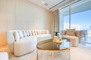 a living room with a white couch and a glass table at FIVE Palm Jumeirah Residences - Mint Stay in Dubai