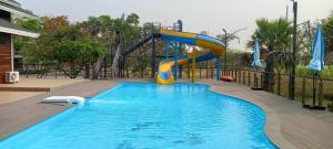 a swimming pool with a slide in the middle at Khwaithai Resort & Homestay - ควายไทย 