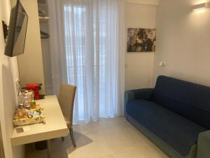 a living room with a blue couch and a table at Divina Holiday - Rooms in Maiori