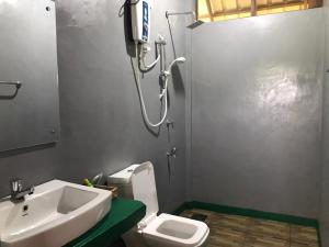 uma casa de banho com um lavatório, um WC e um chuveiro em Chena Huts Eco Resort em Sigiriya