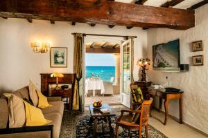 a living room with a view of the ocean at Hotel Le Maquis in Porticcio