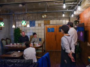 a group of people sitting at a table in a restaurant at HOSTEL OE in Yoshinogawa