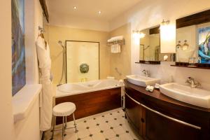 a bathroom with two sinks and a bath tub and a tub at Hotel Le Maquis in Porticcio