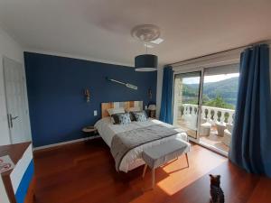 MiremontにあるMa villa au bord de l'eauの青い壁のベッドルーム1室(大型ベッド1台付)