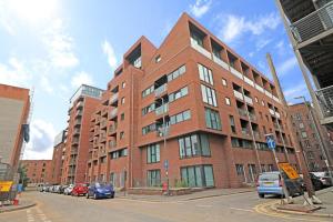 a red brick building with cars parked in front of it at Lovely Modern Central & Spacious in Liverpool