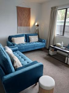 uma sala de estar com um sofá azul e uma mesa em Kea Retreat em Franz Josef