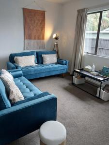 Kea Retreat في فرانز جوزيف: غرفة معيشة مع أريكة زرقاء وطاولة