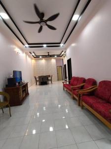 salon z kanapami i wentylatorem sufitowym w obiekcie KS Villa Homestay KKB w mieście Kampong Peruntun