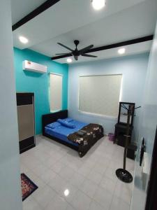 Kampong PeruntunにあるKS Villa Homestay KKBのベッド1台と天井ファン付きの客室です。