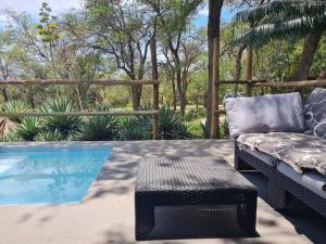 un patio con sofá y mesa junto a la piscina en Leopard Rock Guest Lodge, en Mica