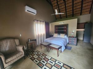 1 dormitorio con 1 cama, 1 sofá y 1 silla en Leopard Rock Guest Lodge, en Mica