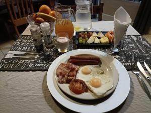 un plato de comida con huevos y salchichas en una mesa en Leopard Rock Guest Lodge, en Mica