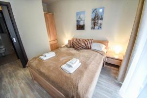a bedroom with a bed with two towels on it at Apartamenty na Wyspie -Apartamenty Stella in Świnoujście