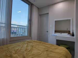 a bedroom with a large bed and a large window at Dasi 2 in Daejeon
