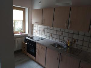 cocina con fregadero, fogones y ventana en Ferienwohnung Elisabeth Biebl, en Neuschönau